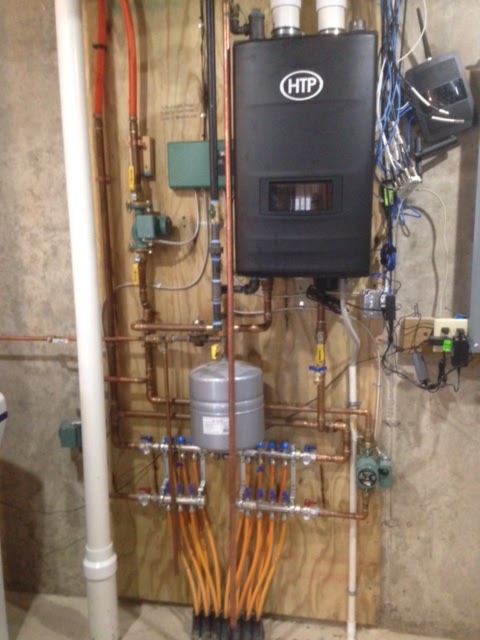HTP wall hung boiler with copper piping and PEX manifold installed by ProTech
